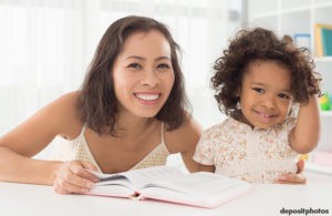 Mother and toddler daughter reading together