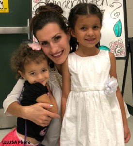 Mother crunching, hugging her two daughters.