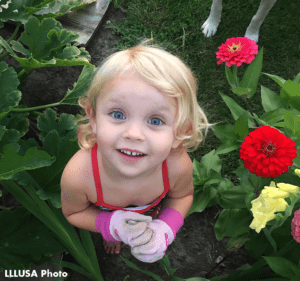 Rebecca daughter Abby looking up to the camera, while in a garden