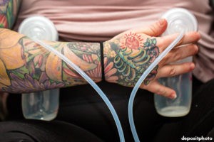 Close up of mother holding pump while expressing milk