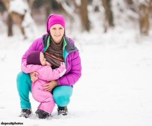 mother breastfeeding her toddler in the snow