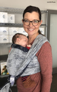 Angie wearing her baby in a carrier at work