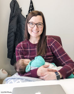 Angie nursing her baby at her desk