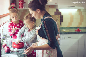 Pregnant mother baking with her two daughters