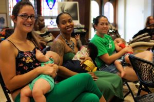 Three moms sitting in a row nursing their babies