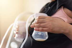 person pumping milk; holding 2 bottles