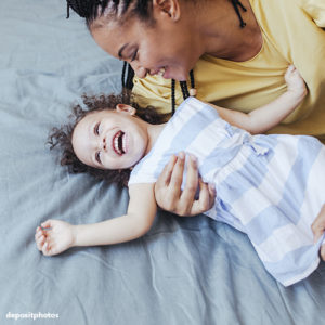 Mother hugging toddler smiling happy