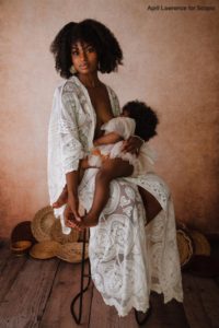 Mother nursing her toddler in white dress