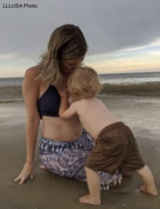 Amanda breastfeeding her son on the beach
