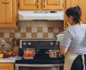 Woman cocking at a stove