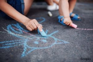 Adult and toddler chalking on sidewalk zoom in of hands