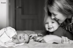 Mother with toddler watching the new baby