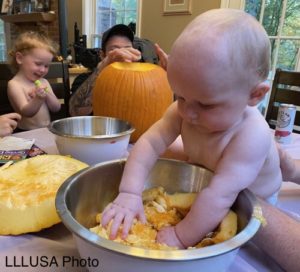 Baby playing with pumpkin seeds