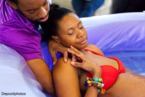 Partner supports mom in water birth