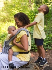 Mom with toddler in carrier and son behind her